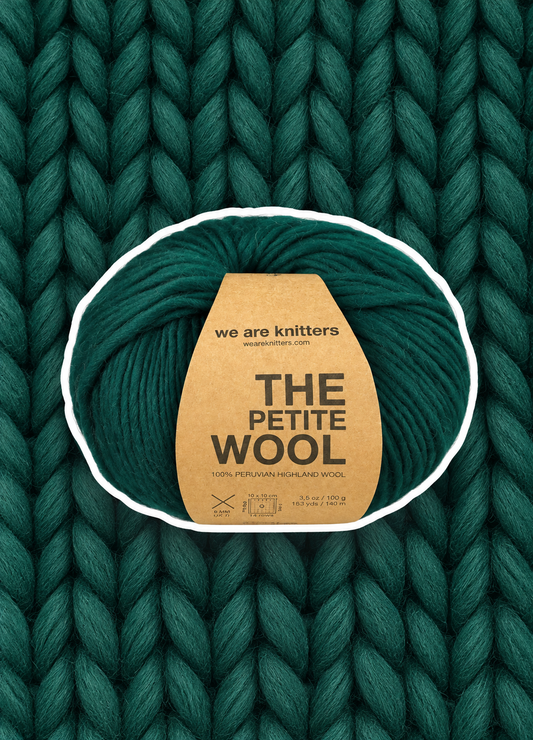 Petite Wool Forest Green yarn ball on a matching knit swatch
