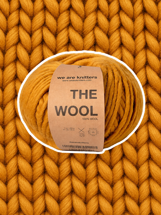 The Wool Ochre yarn ball on a matching knit swatch